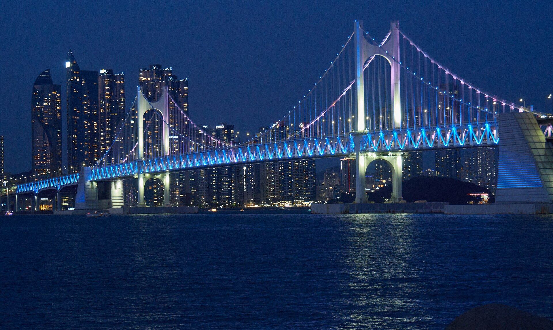 Gwangan Bridge lit up in blue over the night sea