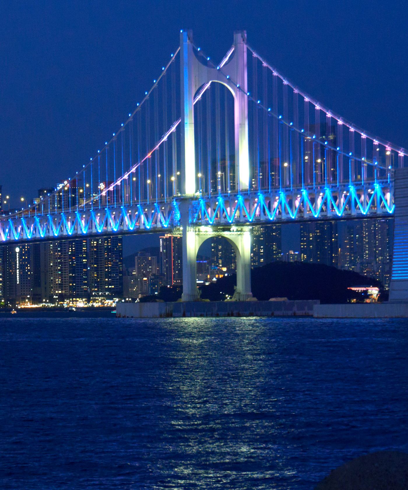 Gwangan Bridge in Busan lit up at night over the sea
